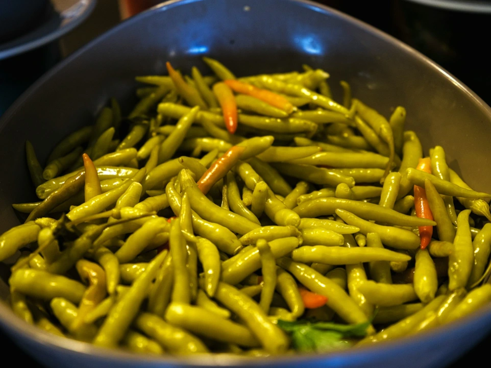 A bowl of small green chili peppers.